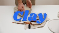 a person is putting clay on a table